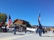 A thumb nail view of Grand Lake, Colorado during Constitution Week in September looking at some of our Veterans marching in the parade as they carry a banners and flags; click here to open a window with a larger picture.